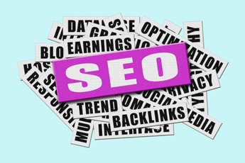 A pile of newspaper clippings with "SEO" prominently displayed in a pink rectangle, surrounded by terms like "Optimization," "Backlinks," "Blog Earnings," and "Trend."